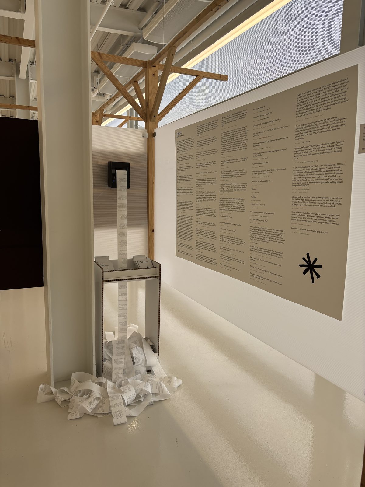 EPICAC installation: thermal printer mounted on wall, spooling printed love letters onto the floor below